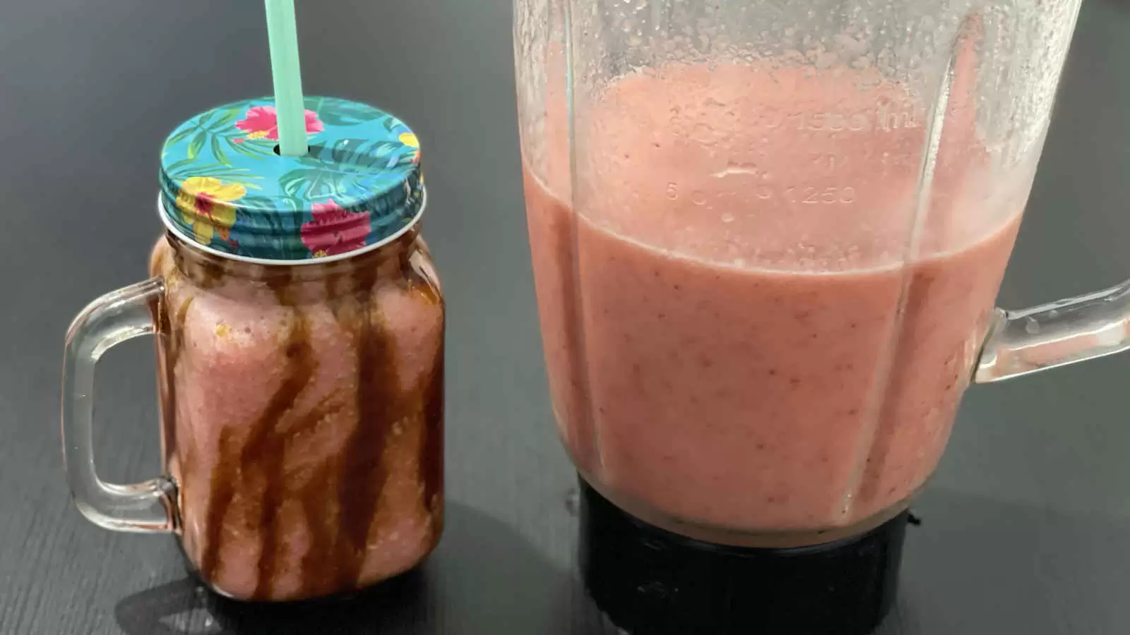 Apple banana and strawberry fruit smoothie in high glass and a blender