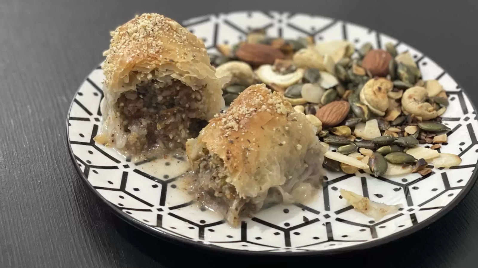 Pieces of baklava and a selection of nuts on a plate