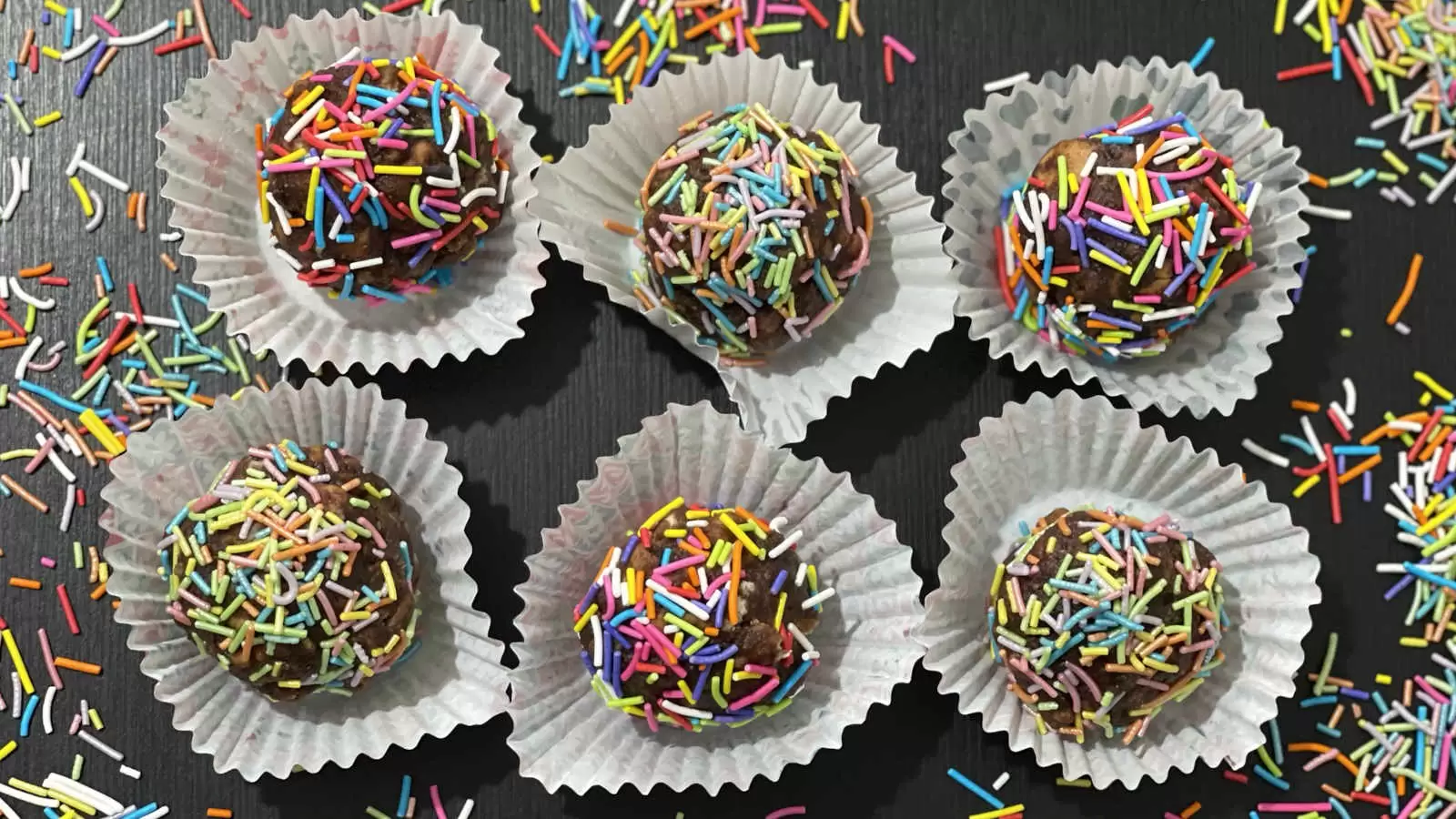 Chocolate balls dish with rainbow sprinkles in baking cups