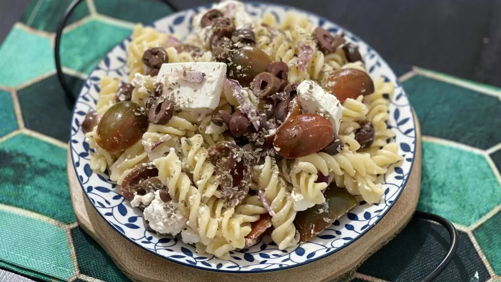 Cooking Pasta salad with Bulgarian cheese and tomatoes on a plate and a napkin underneath