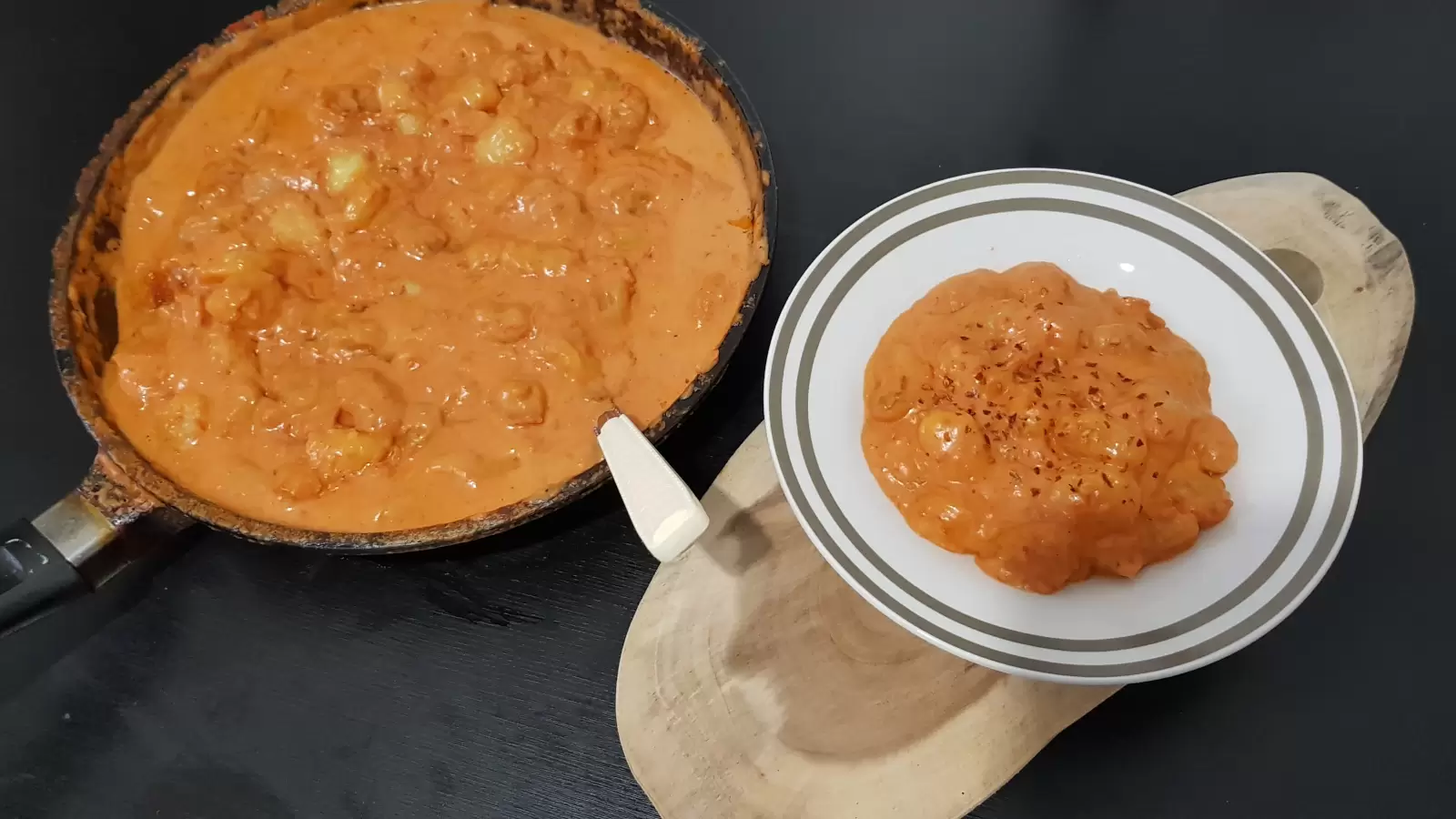Creamy Tomato Gnocchi recipe on a plate on a wooden board