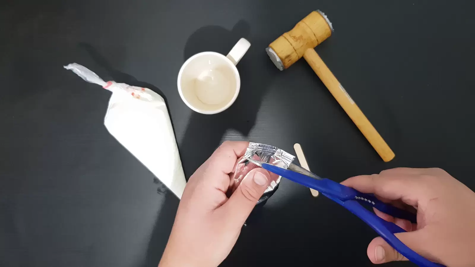 Kitchen hammer, scissors cutting package of Oreo cookies, cup, piping bag with whipped cream