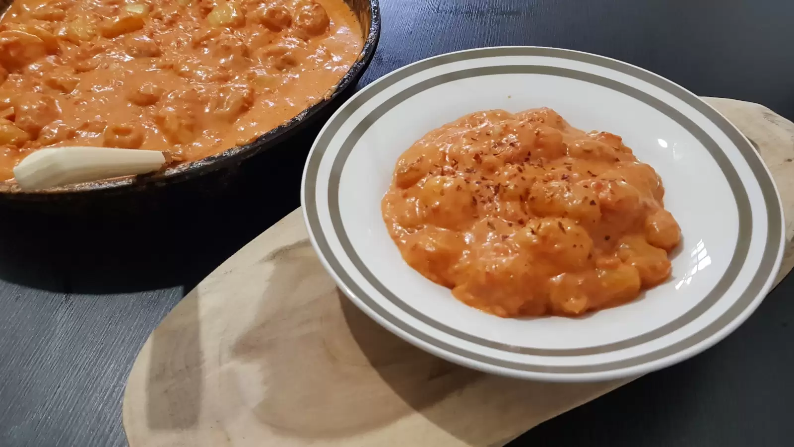 Delicious Creamy Tomato Gnocchi on a plate on a wooden board