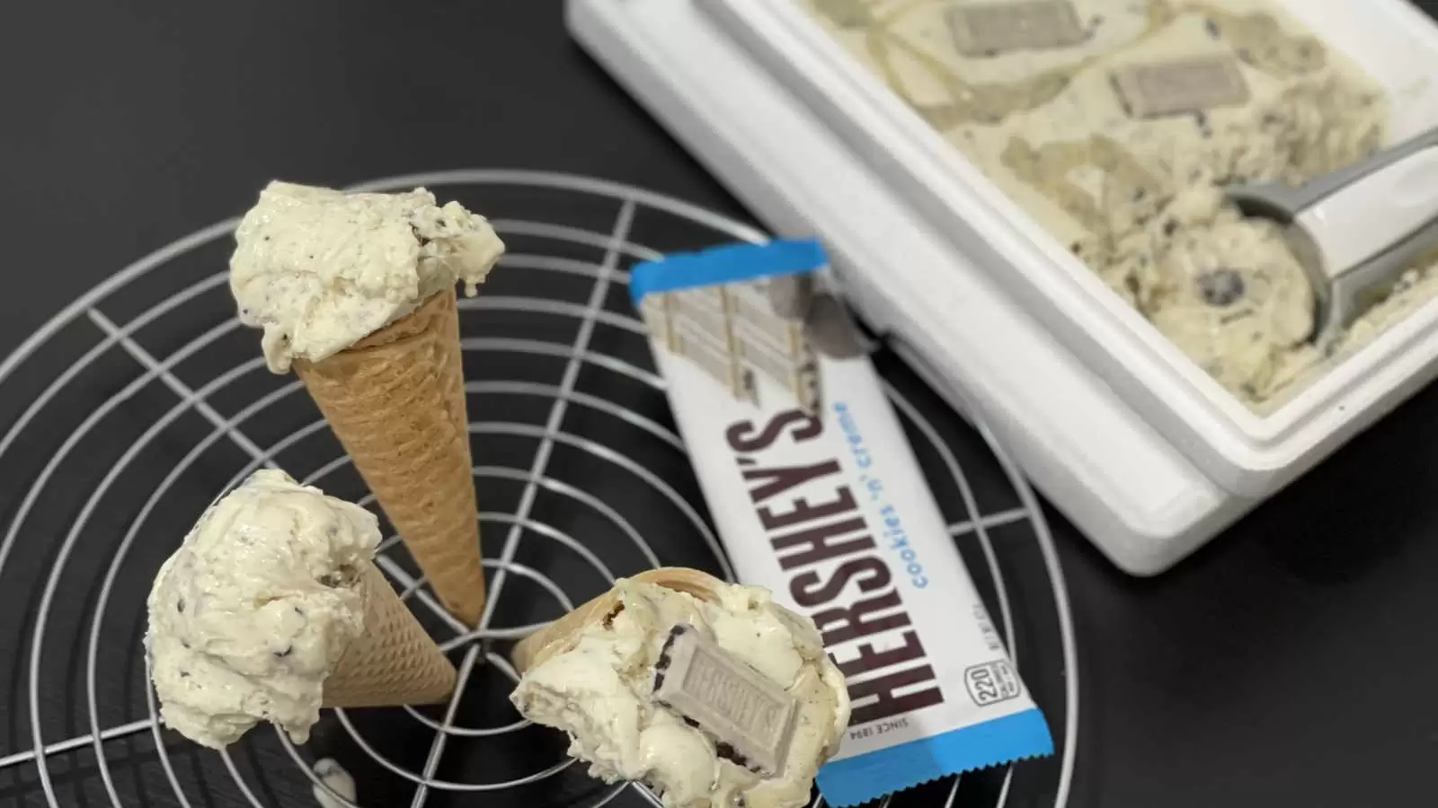 Delicious Hersheys ice cream in a box with an ice cream scoop a cooling rack with three ice cream cones a pack of Hersheys chocolate