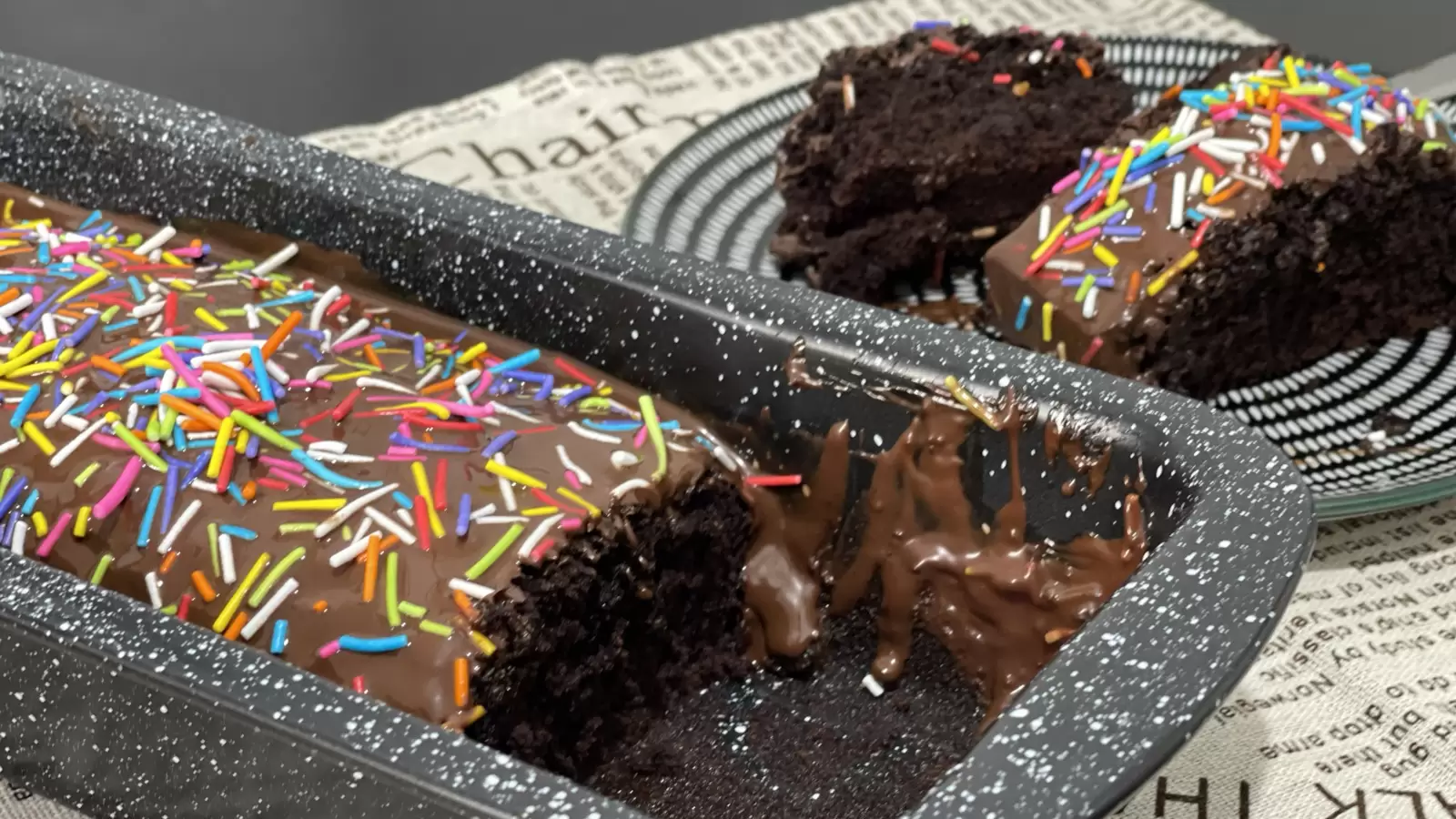 Two pieces of soft chocolate cake on a plate a mold with delicious chocolate cake