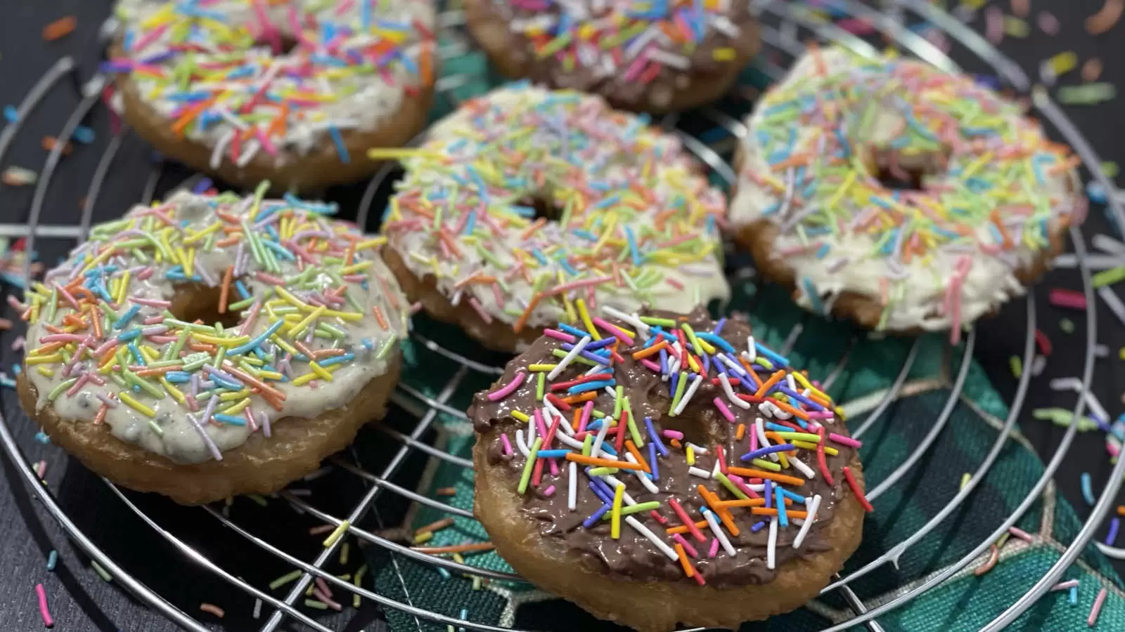 Delicious Puff pastry doughnuts on a cooling rack and a napkin underneath