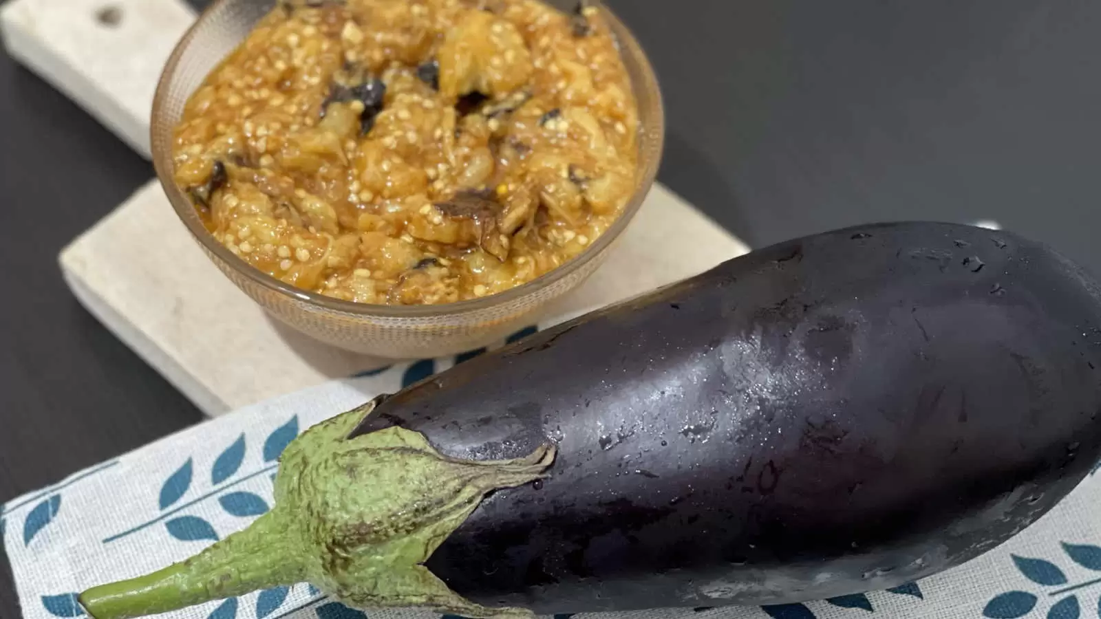 Eggplant on a napkin eggplant salad recipe in a bowl on a wooden tray