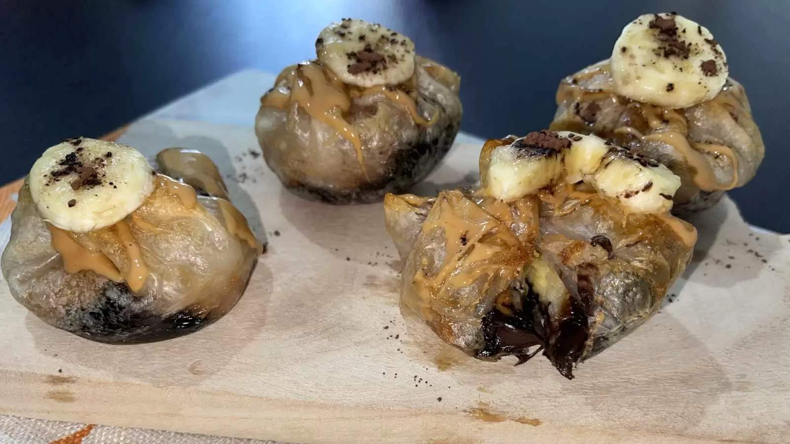 Four units of Gluten free Peanut Butter Chocolate and Banana Rice Paper on a wooden tray