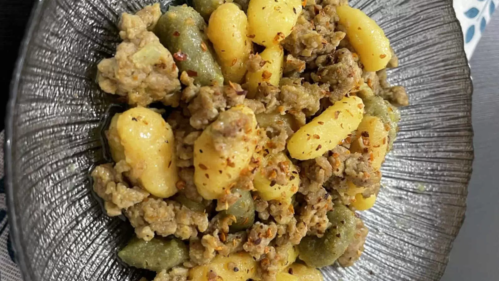 Gnocchi Bolognese dish on a plate under a napkin