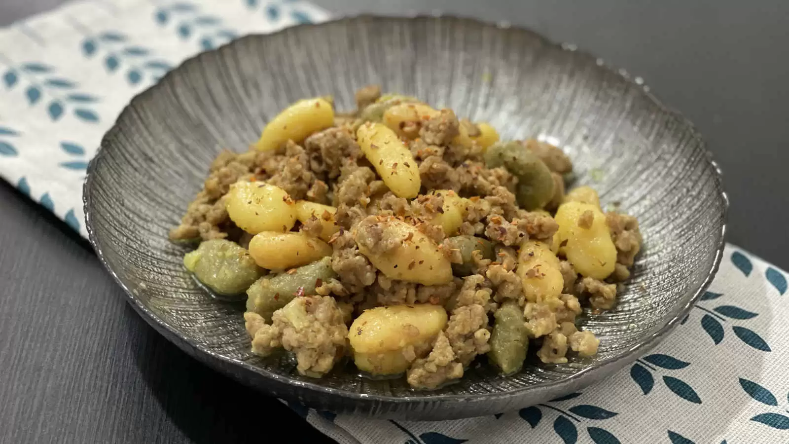 Gnocchi Bolognese meal on a plate under a napkin