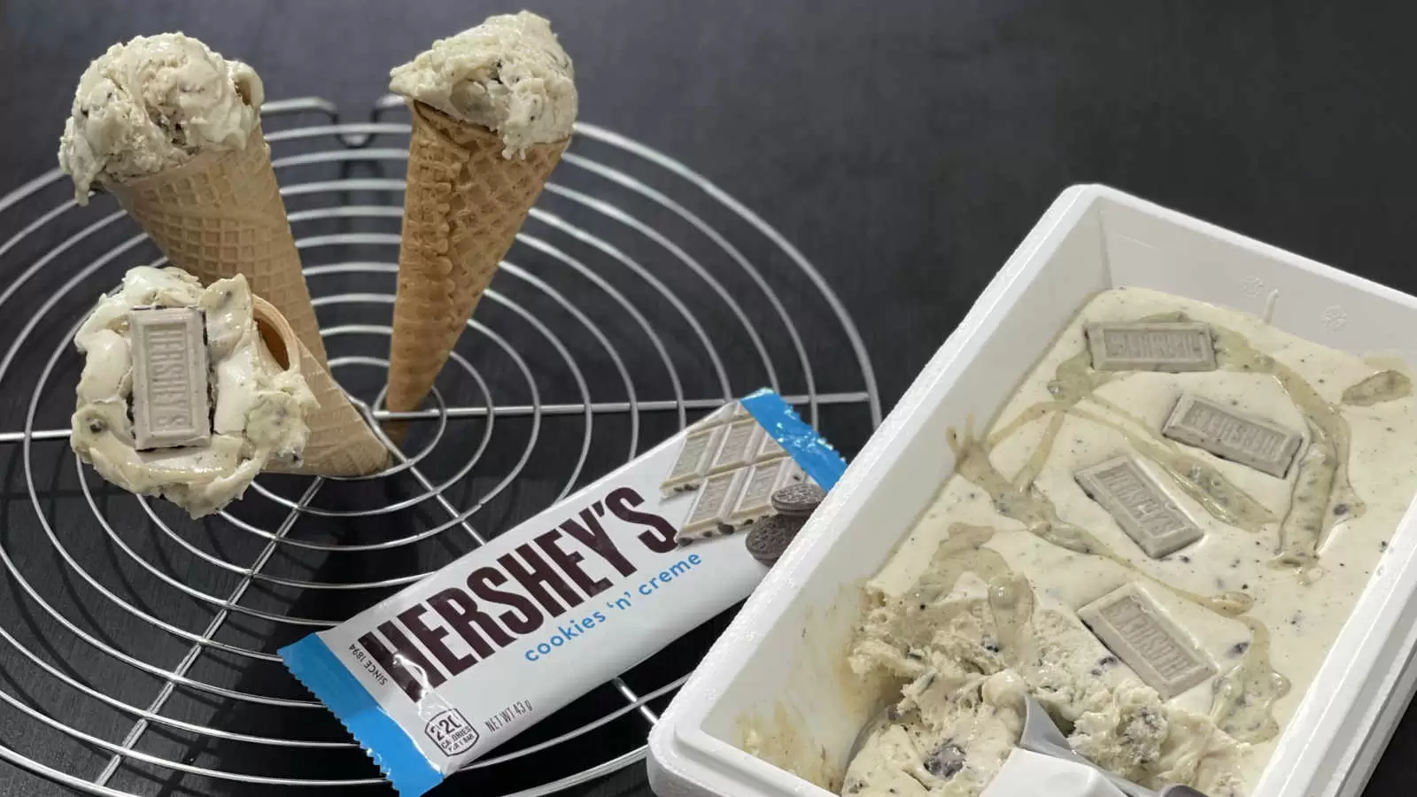 Hersheys ice cream in a box with an ice cream scoop a cooling rack with three ice cream cones a pack of Hersheys chocolate