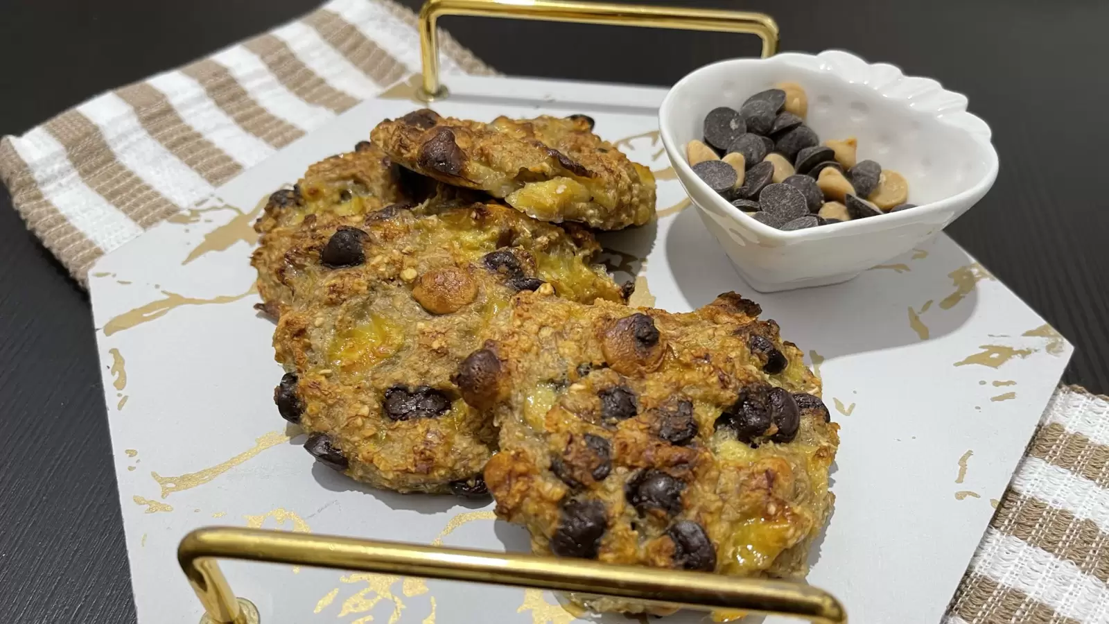 Homemade cookies on a tray a bowl of chocolate chips on the table