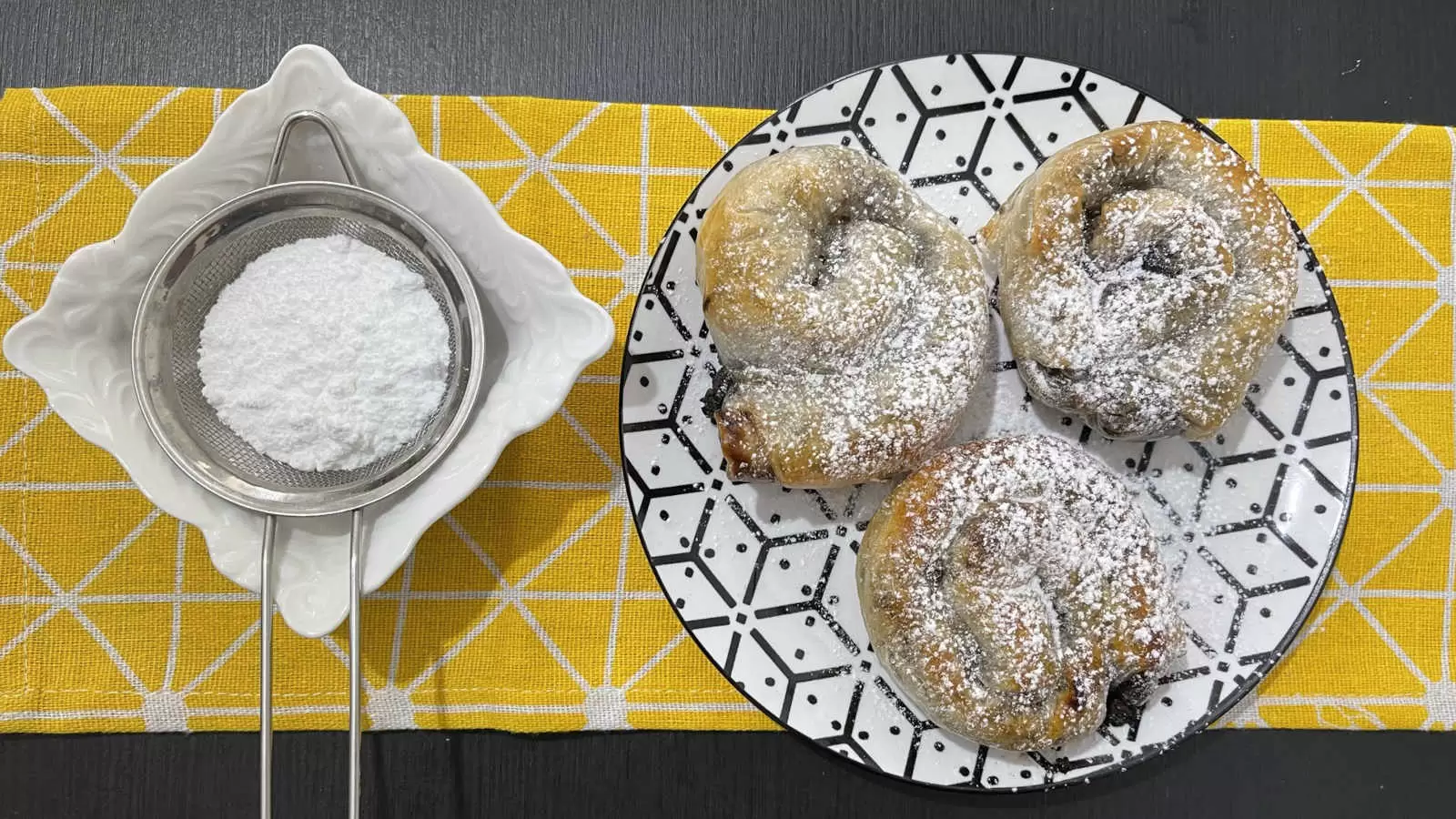 Homemade Three Chocolate rice paper on a plate a bowl with powdered sugar under a yellow napkin on the table