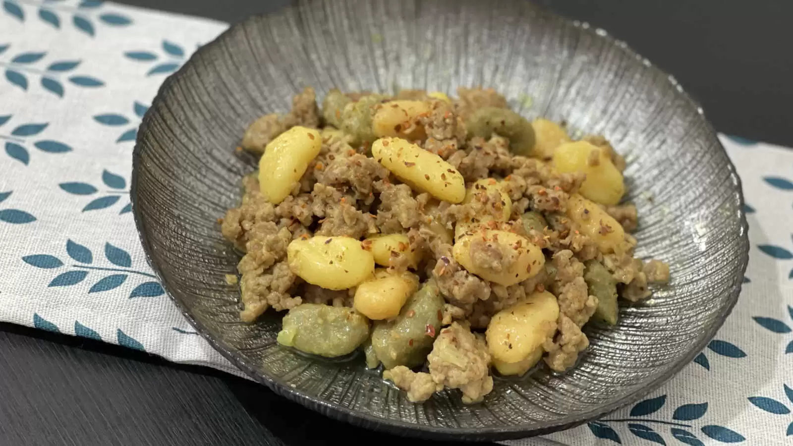 Homemade Gnocchi Bolognese on a plate under a napkin