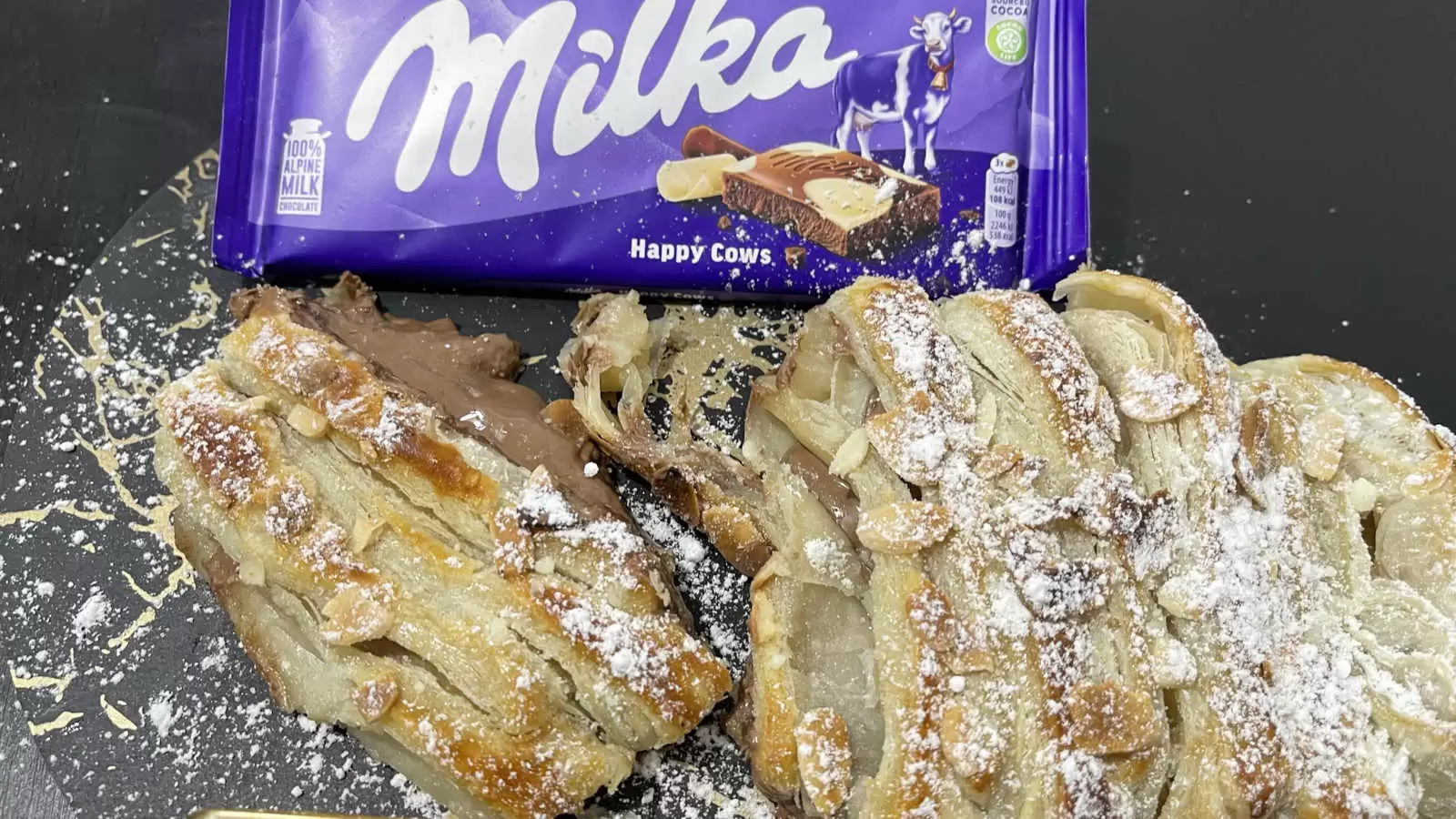 Homemade Milka chocolate bar puff pastry with Milka chocolate and powdered sugar on a plate on a table