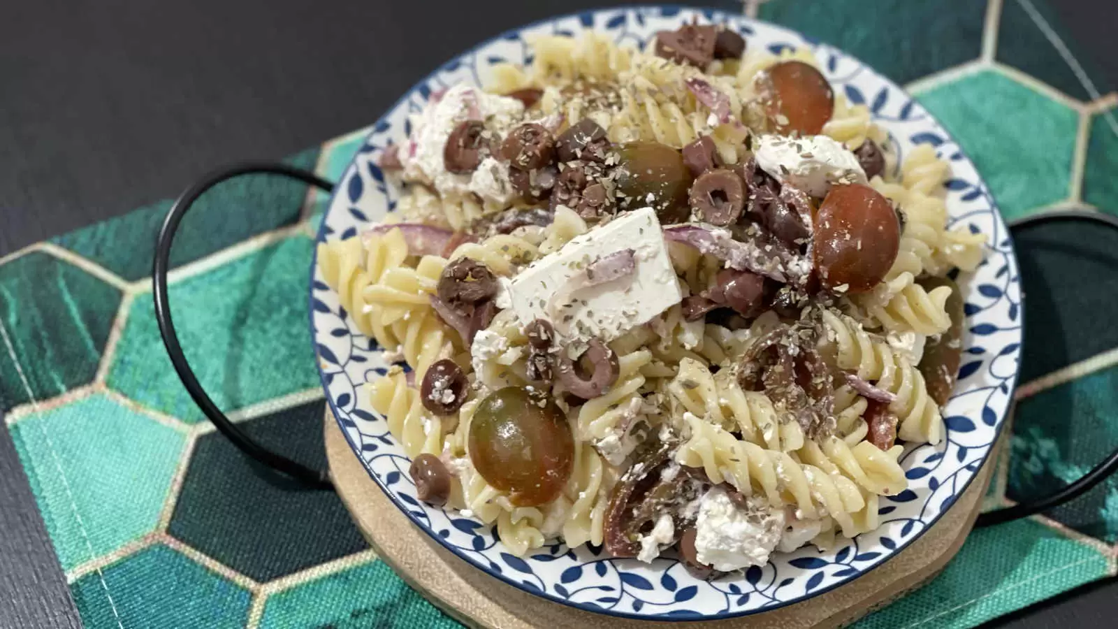 Pasta salad with Bulgarian cheese and tomatoes on a plate and a napkin underneath