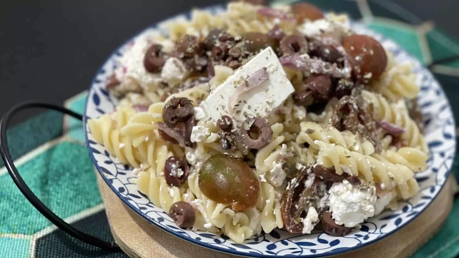 Pasta salad with Bulgarian cheese and tomatoes recipe on a plate and a napkin underneath