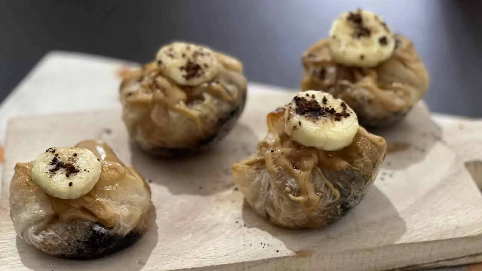 Four units of Peanut Butter Chocolate and Banana Rice Paper on a wooden tray