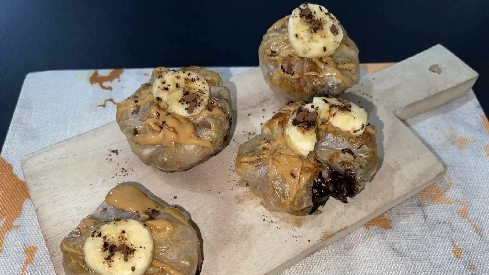 Four units of Peanut Butter Chocolate and Banana Rice Paper dish on a wooden tray