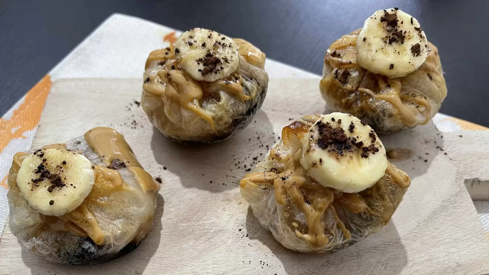 Four units of Peanut Butter Chocolate and Banana Rice Paper recipe on a wooden tray