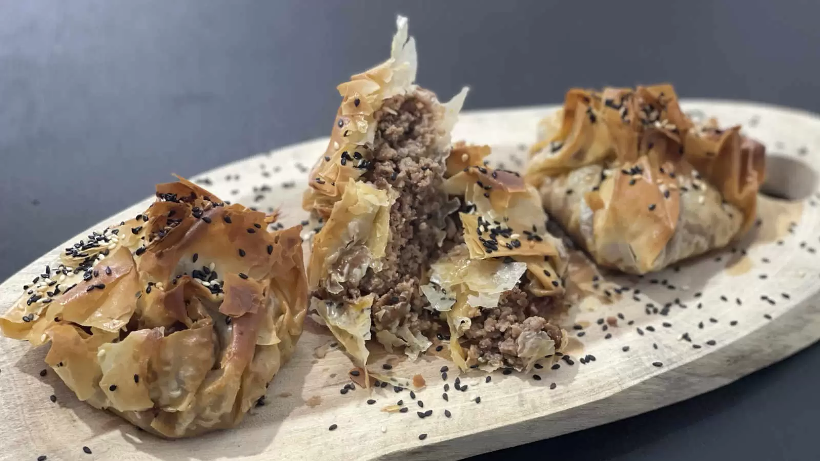 Three Phyllo Dough Beef Pie dish on a wooden board