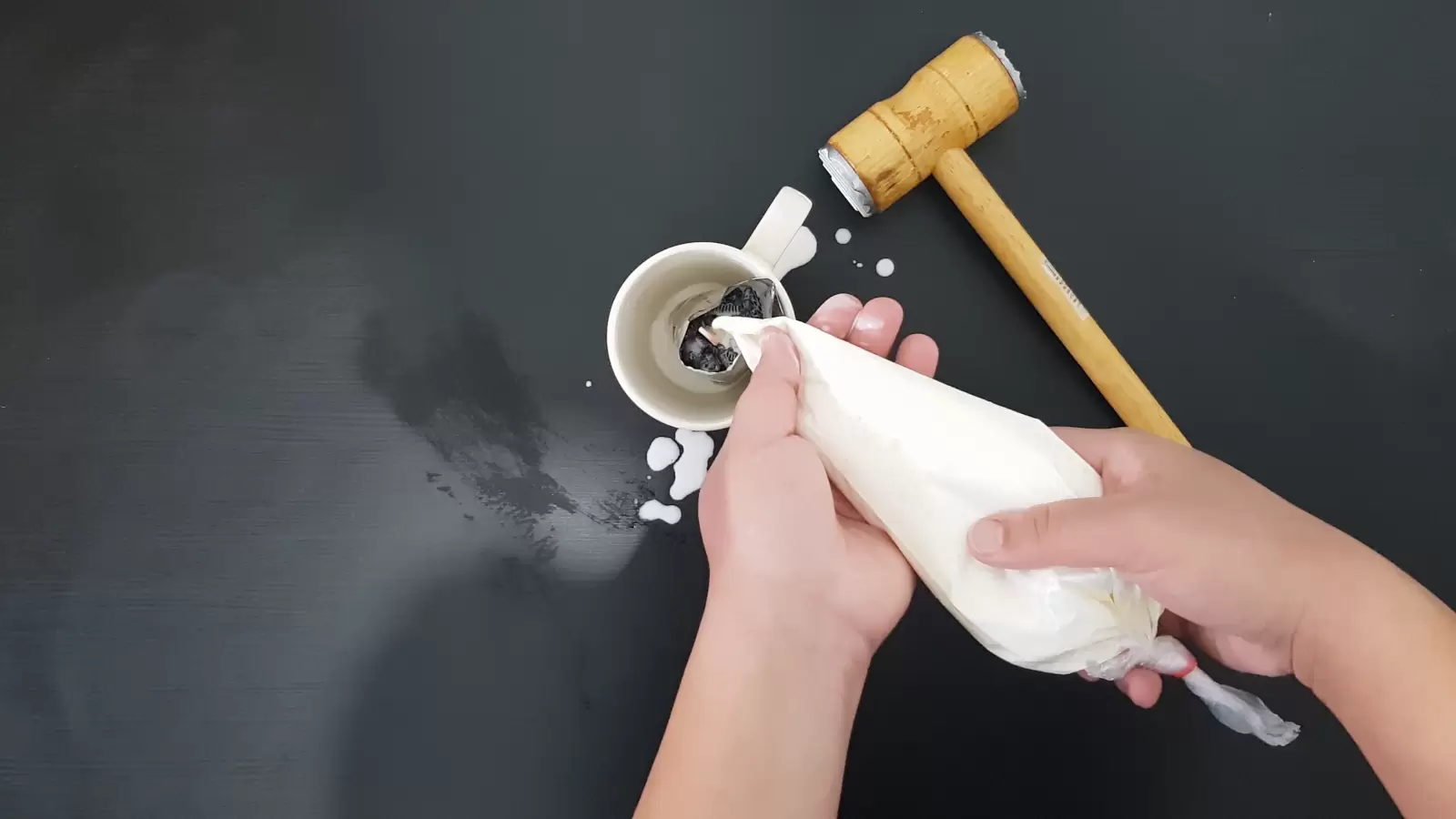 Kitchen hammer, piping bag with whipped cream into package of Oreo cookies in cup