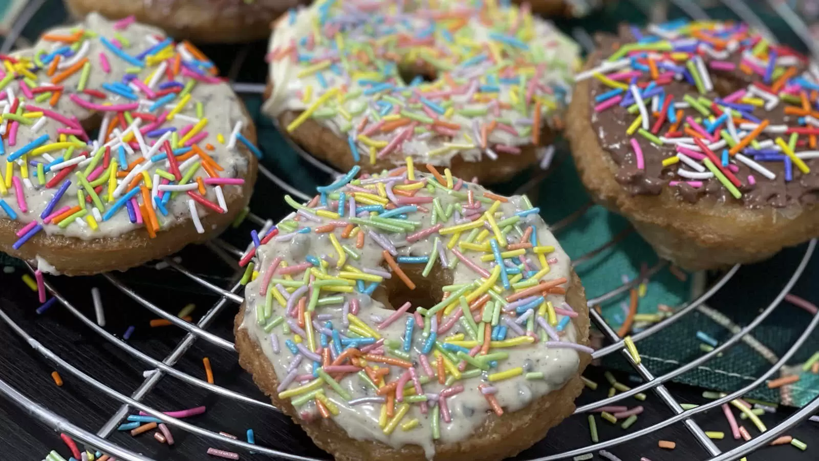 Puff pastry doughnuts recipe on a cooling rack and a napkin underneath