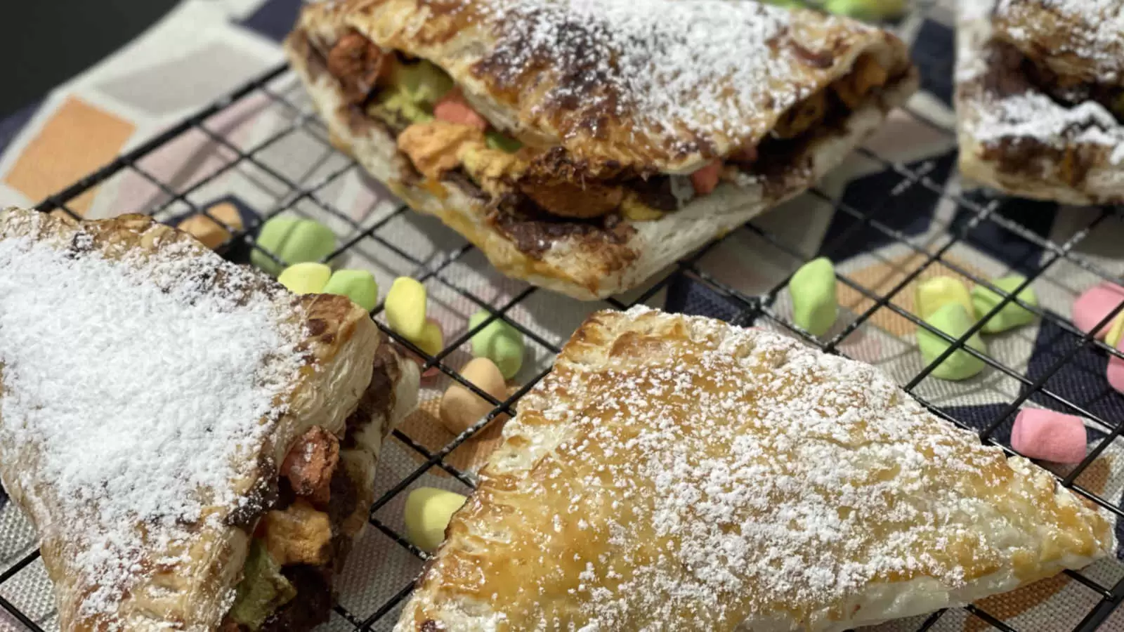 Puff pastry smores on a tray sprinkled marshmallow napkin underneath