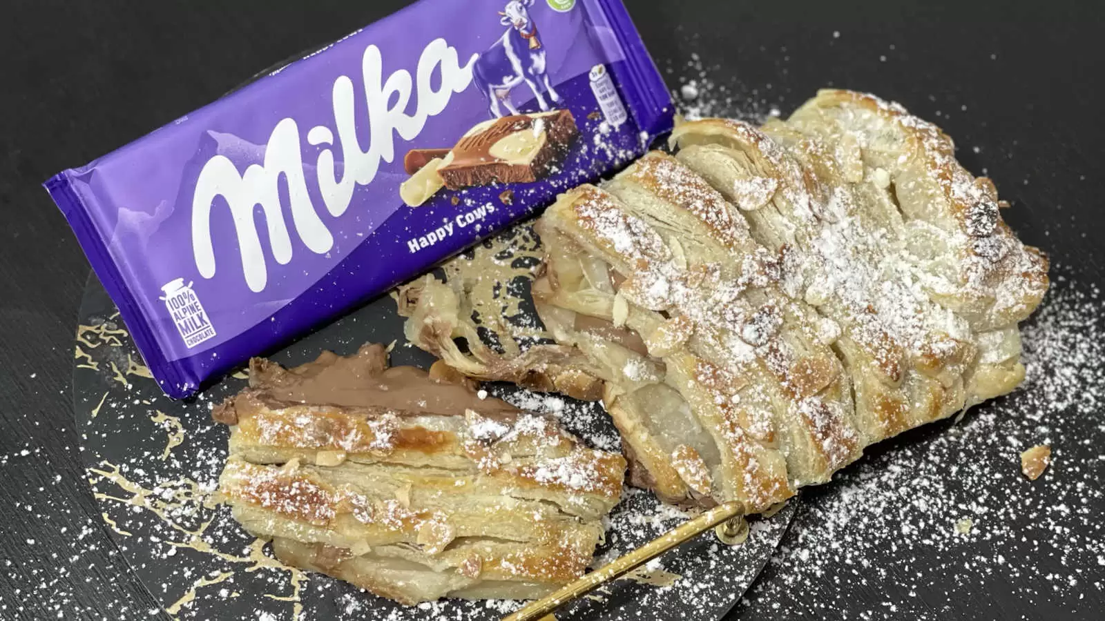 Milka chocolate bar puff pastry with Milka dish chocolate and powdered sugar on a plate on a table