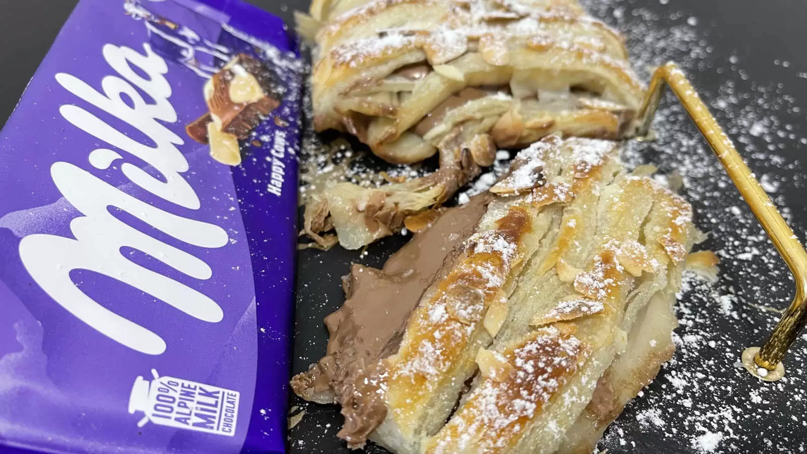 Milka chocolate bar puff pastry with Milka chocolate recipe and powdered sugar on a plate on a table