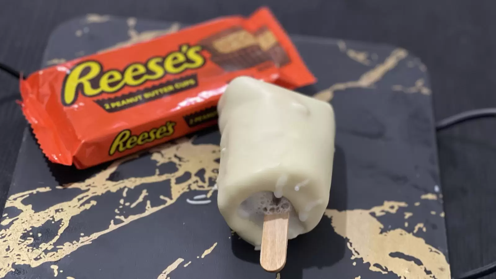 A pack of Reeses next to Reeses ice cream dish placed on a tray on a table