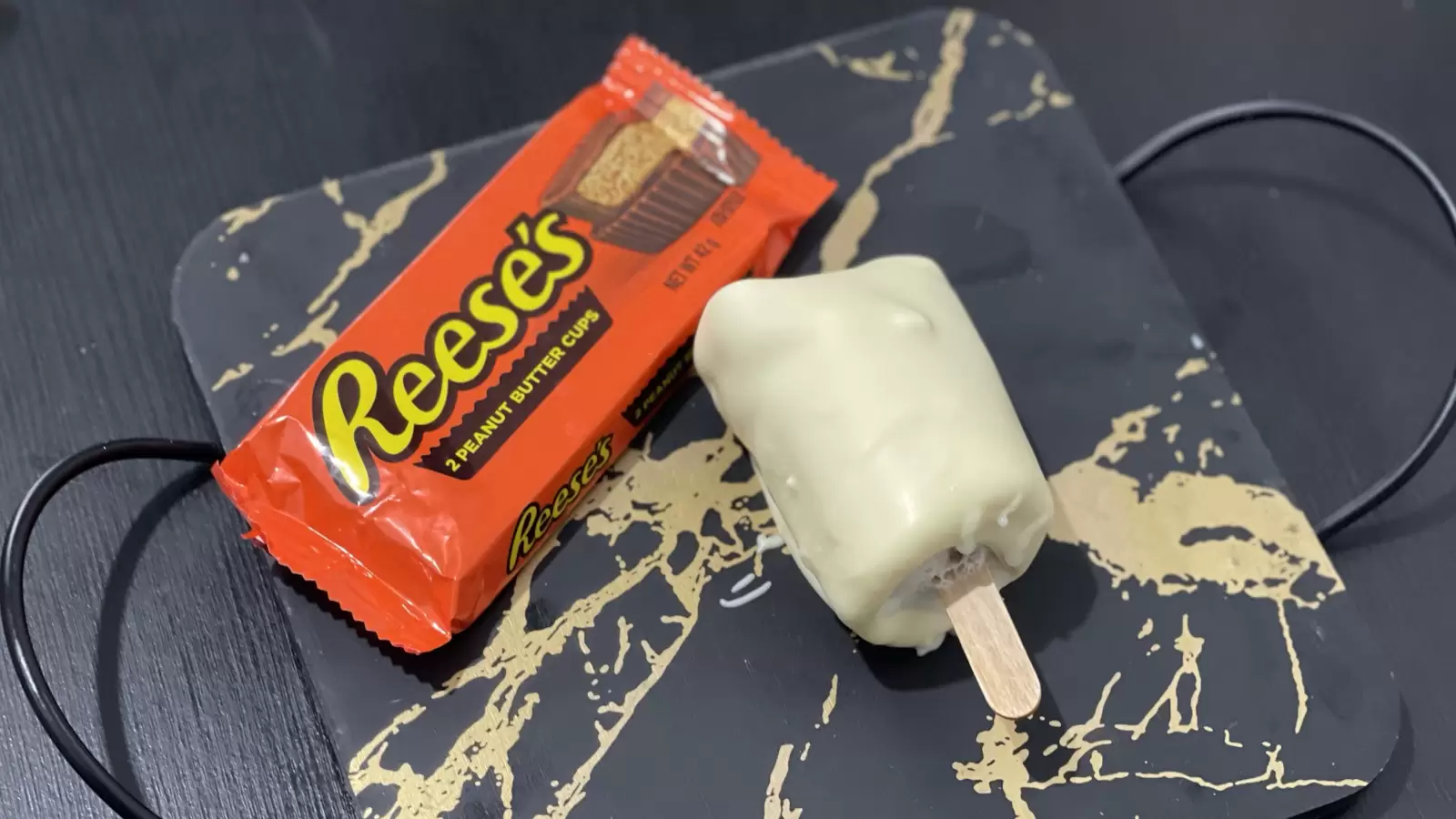 A pack of Reeses next to Reeses ice cream recipe placed on a tray on a table