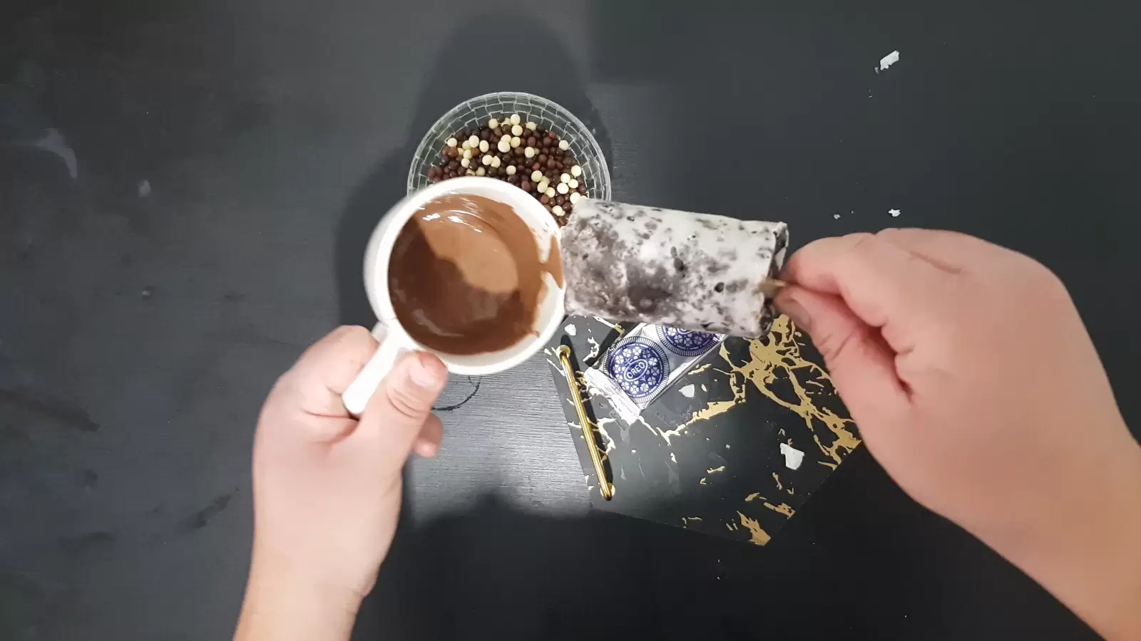 Oreo ice cream, cup with melted milk chocolate, chocolate candies