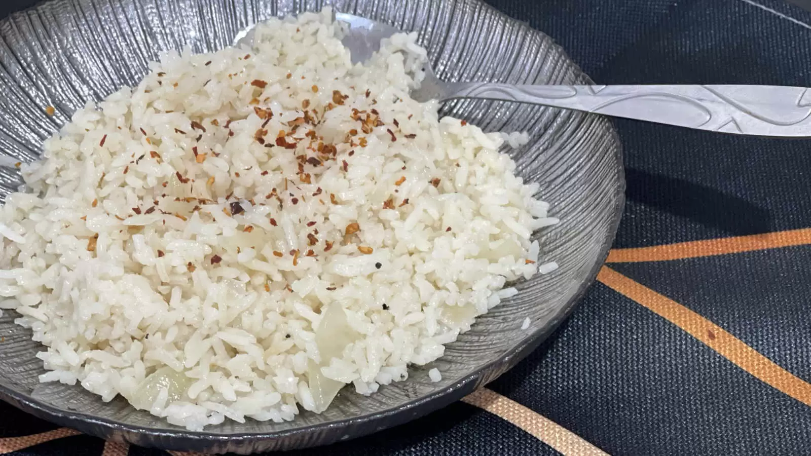 Rice on a plate with a spoon under a napkin