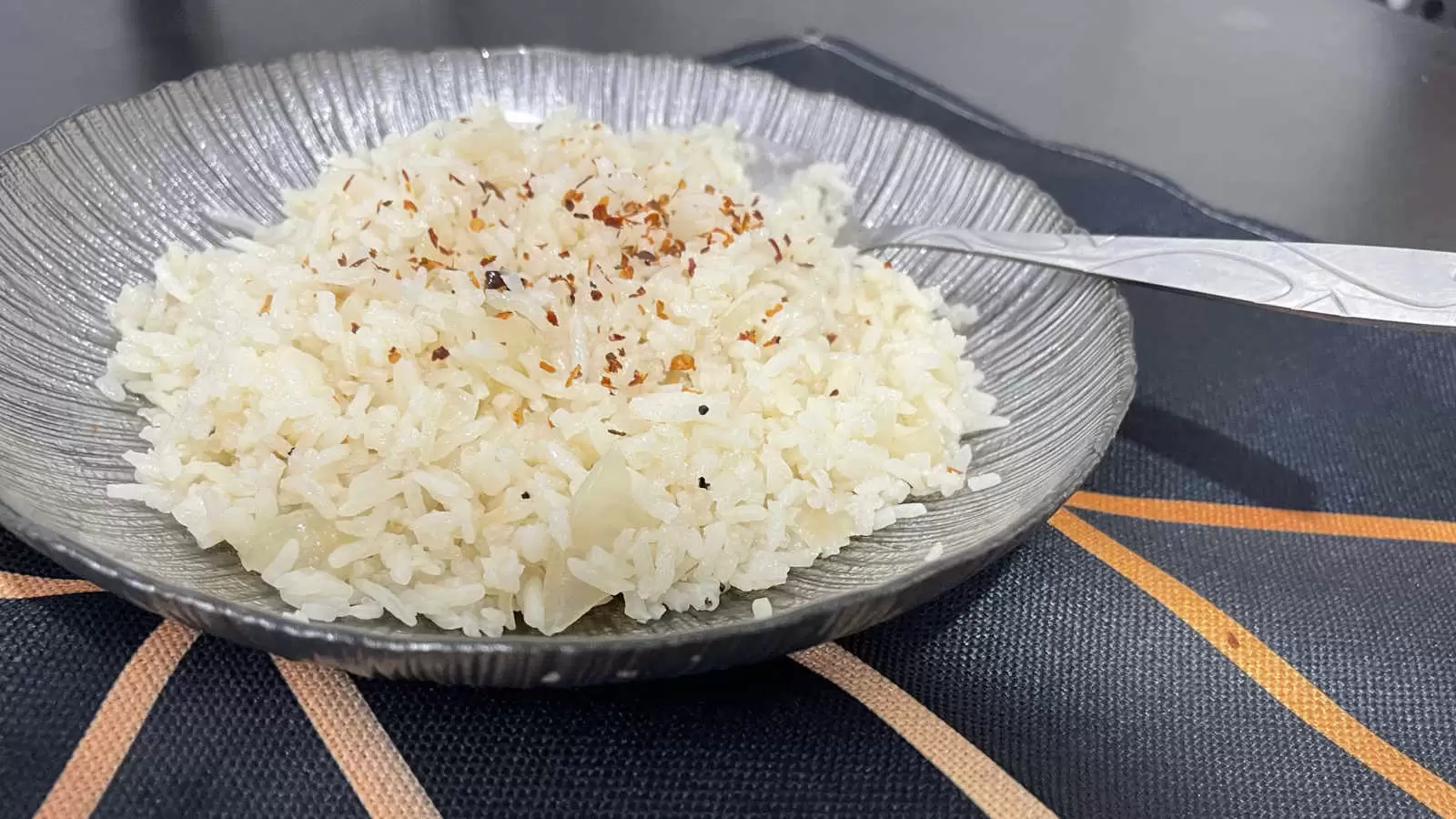 Rice dish on a plate with a spoon under a napkin