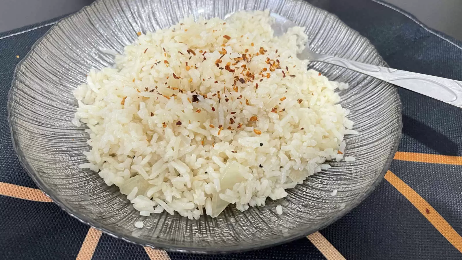 Rice meal on a plate with a spoon under a napkin