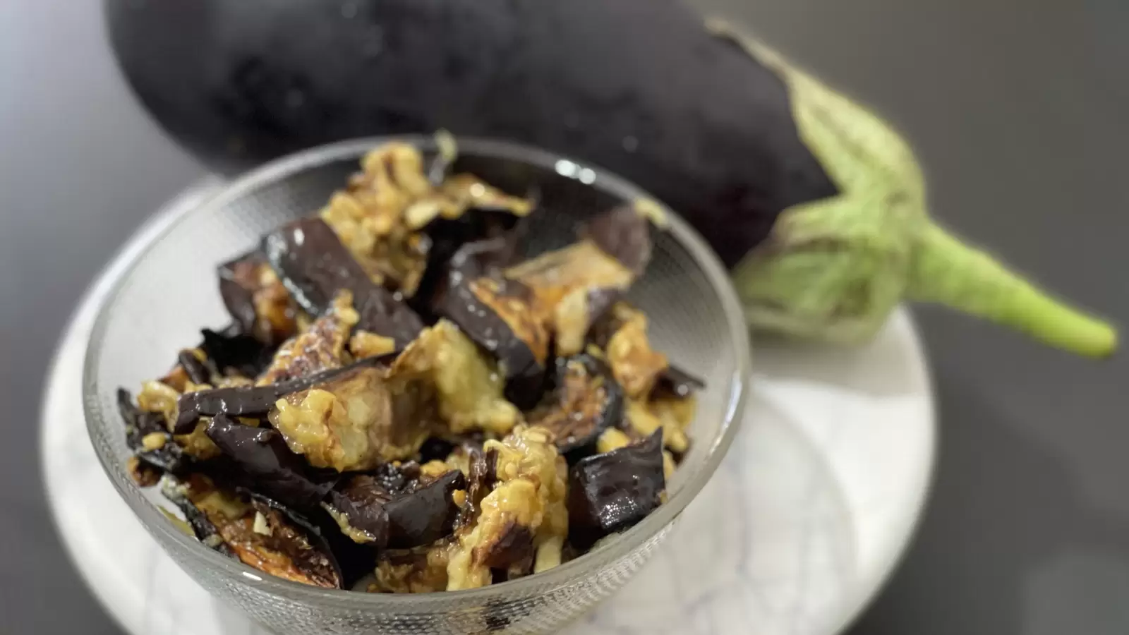 Eggplant and eggplant salad recipe next to it in a bowl on a tray on the table