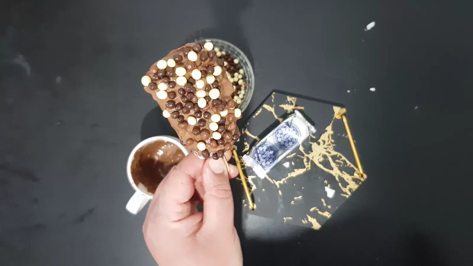 Chocolate-coated Oreo ice cream and chocolate candies, package of Oreos, tray, cup with melted chocolate