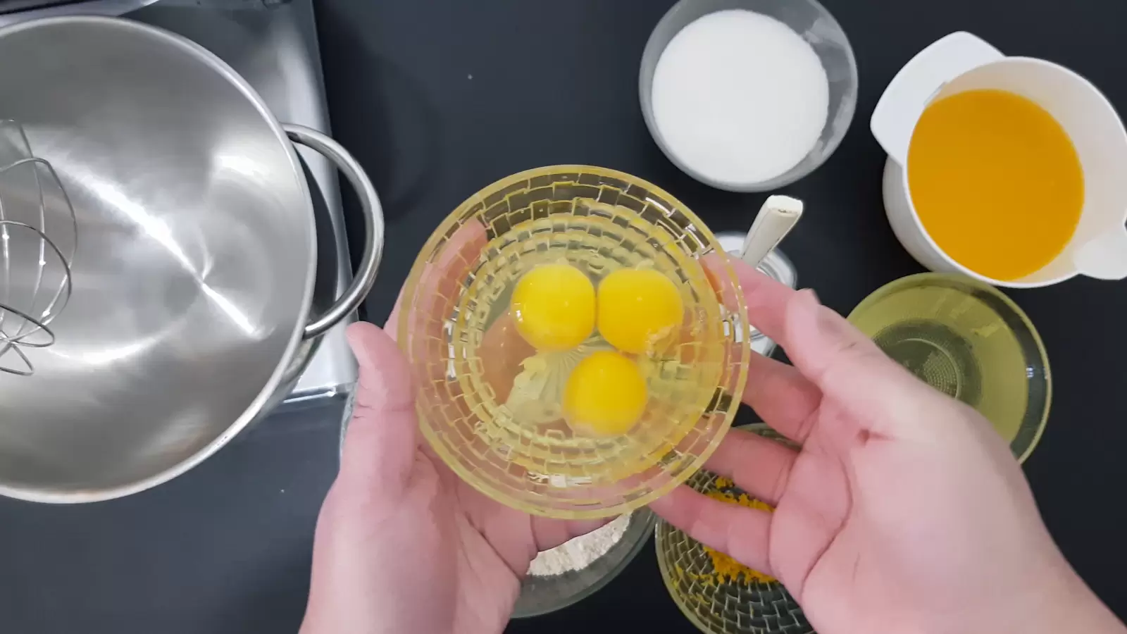 Bowl with three eggs, mixer bowl, bowl with sugar, bowl with oil, bowl with orange juice