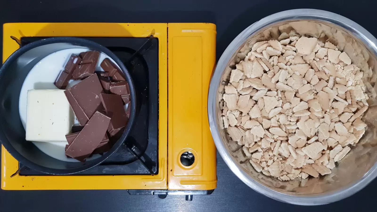 A bowl with biscuits, a pot with chocolate, butter and milk