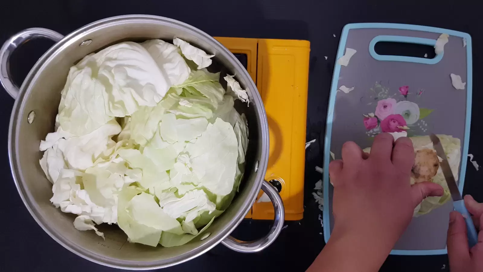 Pot with cabbage leaves, cutting tray, knife