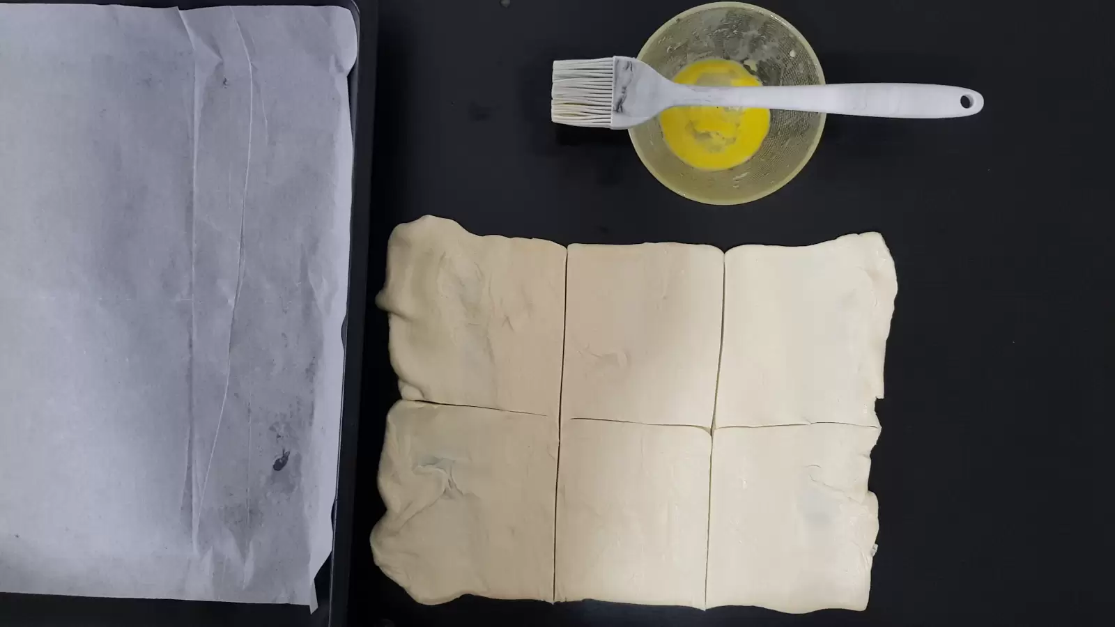Puff pastry cut into 6 cubes, bowl with egg and brush. Baking pan and baking paper.