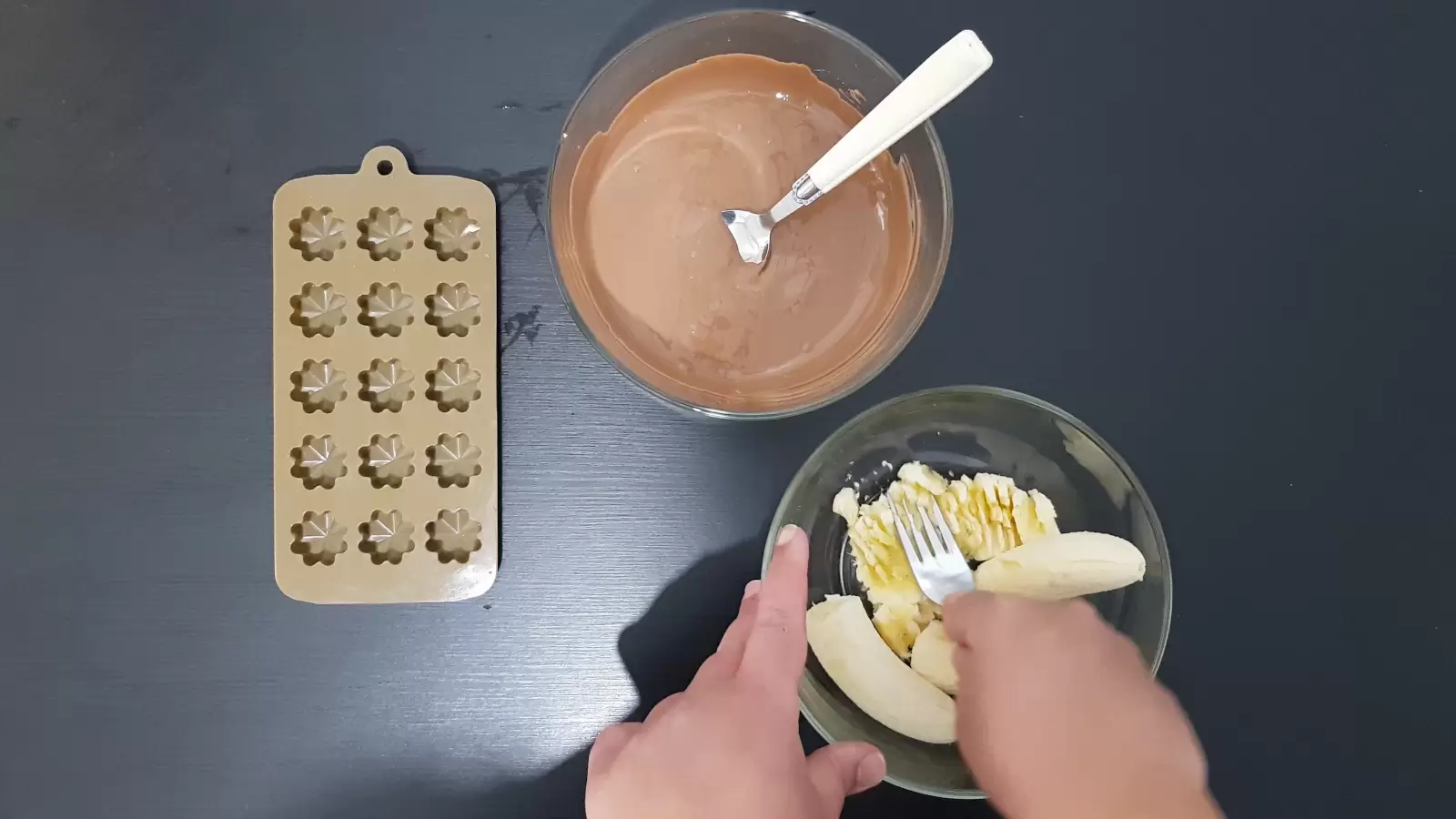 Bowl with bananas and fork, bowl with milk chocolate, pan