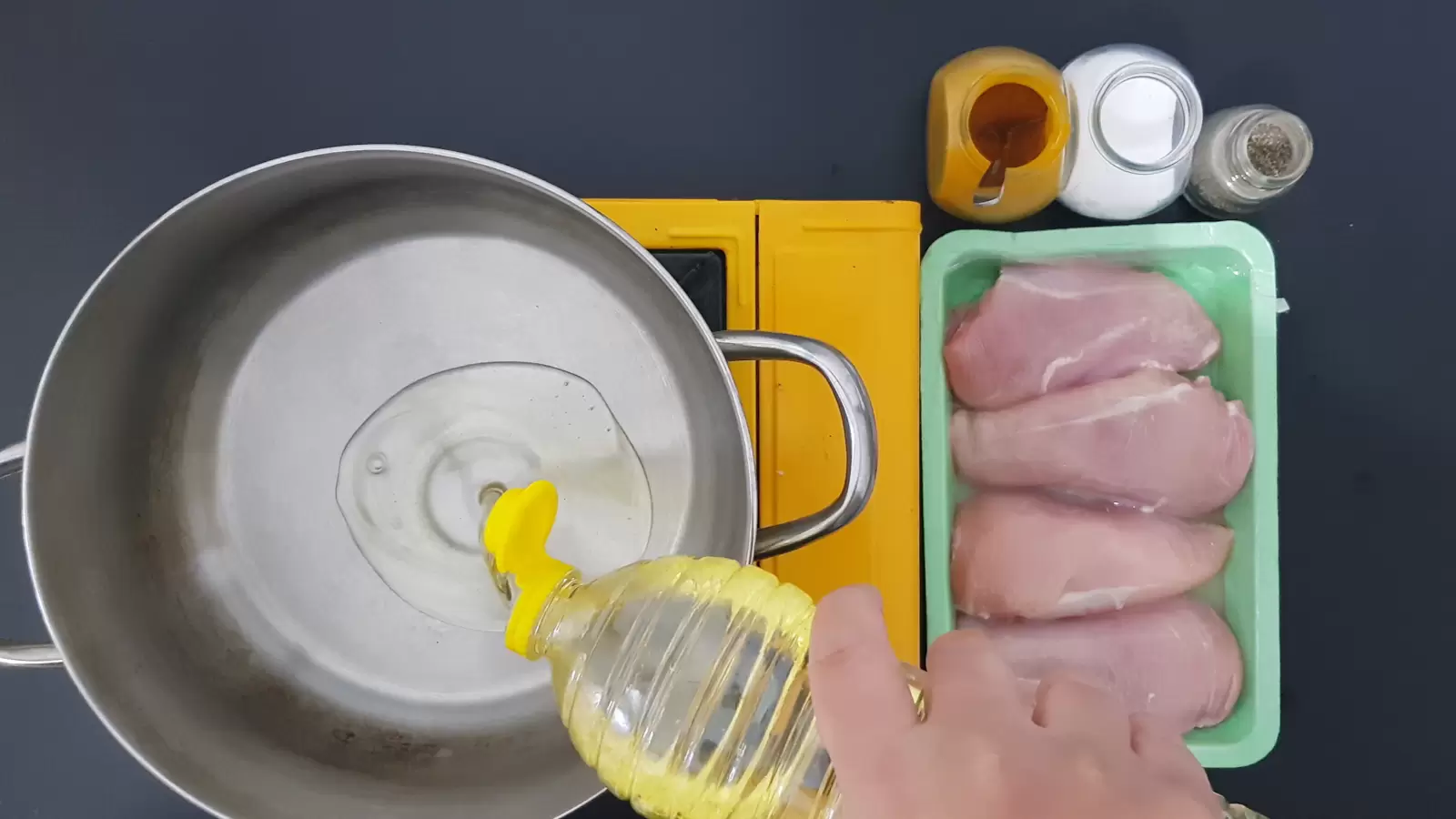 spices, a mold with 4 chicken breasts, oil poured into the pot