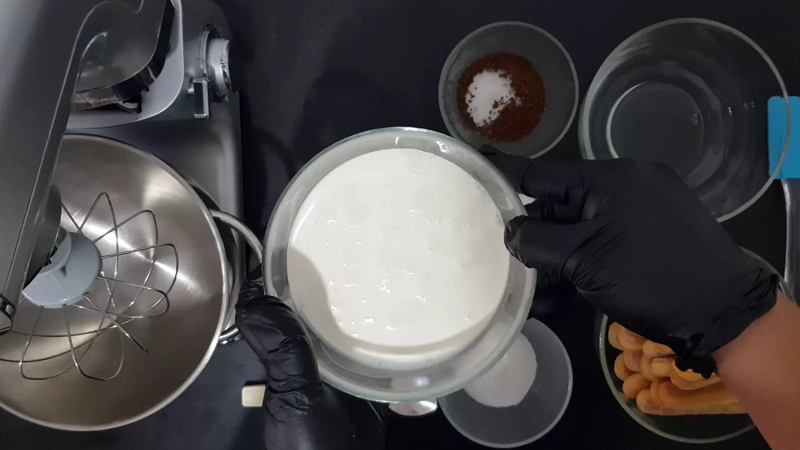 Bowl with water, bowl with coffee and sugar, bowl with ladyfingers, bowl with sugar, mixer bowl and whisk, bowl with cream