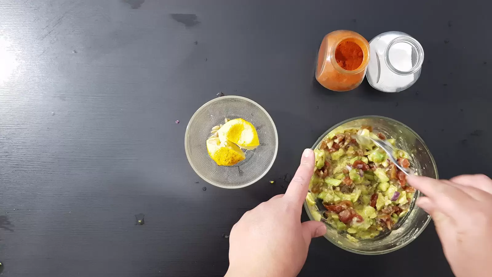 Spices, a bowl with tomatoes and avocado, lemon peel in a bowl