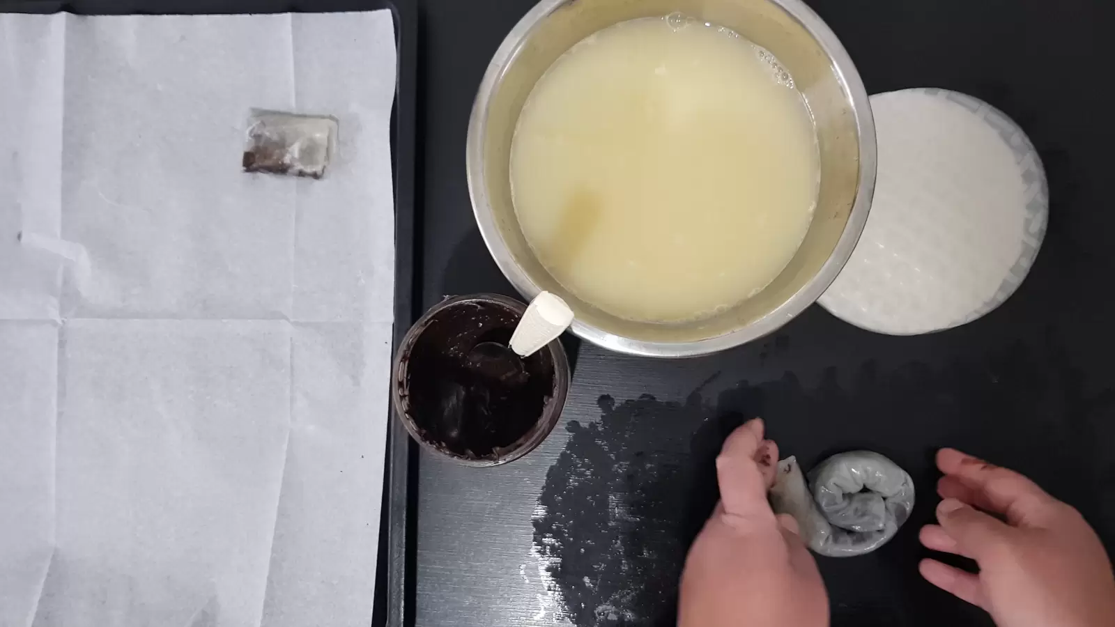 Rice paper, a bowl with water and egg, a jar with chocolate spread and a spoon, three rice papers next to each other and chocolate spread on top, rolled into a snail, a baking sheet with baking paper and a rice paper pastry