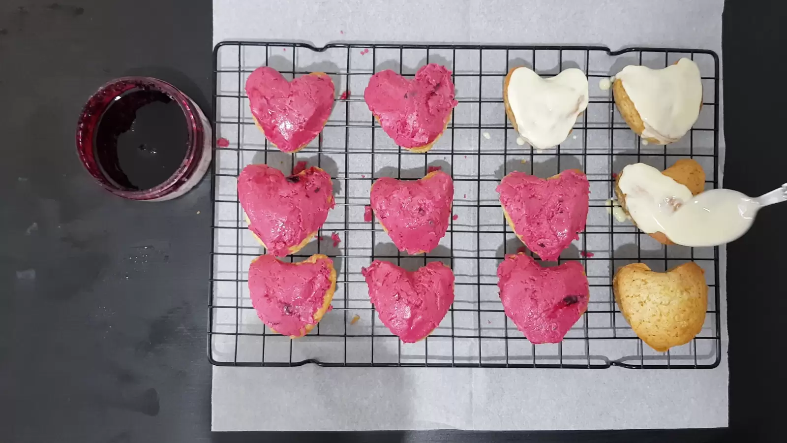 Vanilla cupcakes, spoon, cooling rack, baking paper, bowl with berries