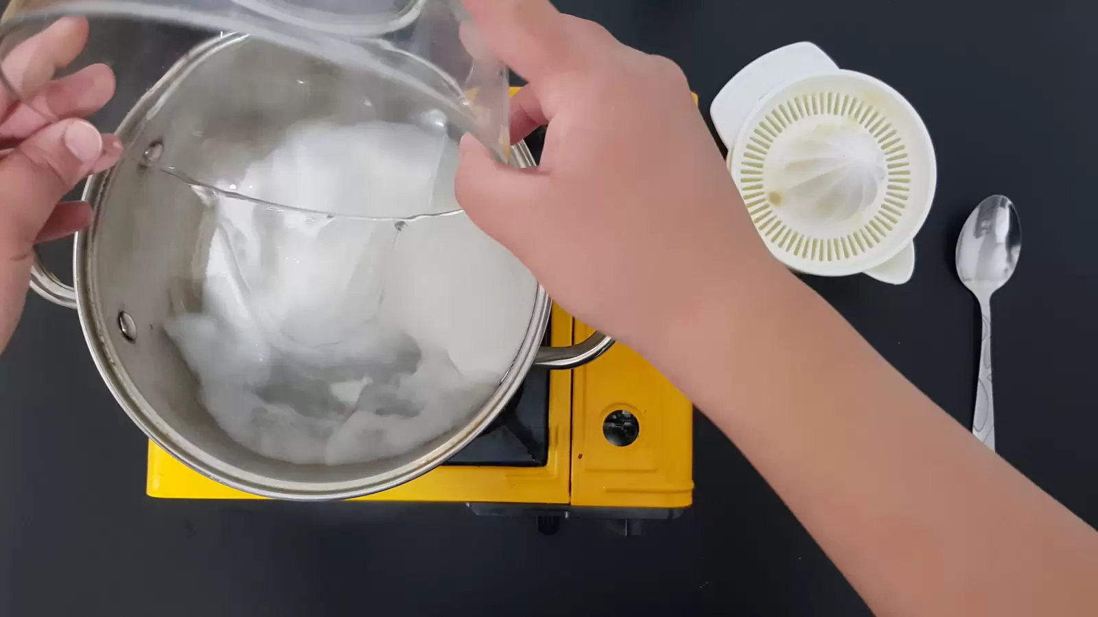 Juicer, spoon, pot with water, bowl with sugar