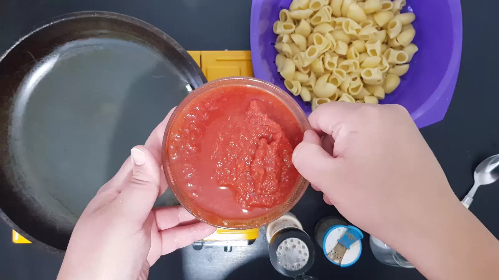 Pan, bowl with pasta, bowl with crushed tomatoes, spoon